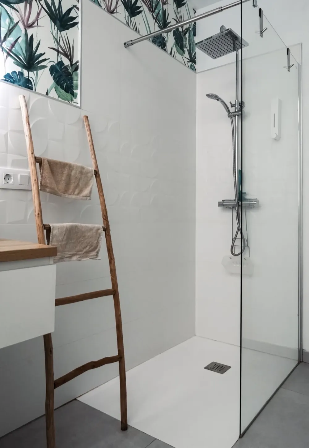 Ducha a ras de suelo con mampara fija, rociador de techo y papel pintado botánico
