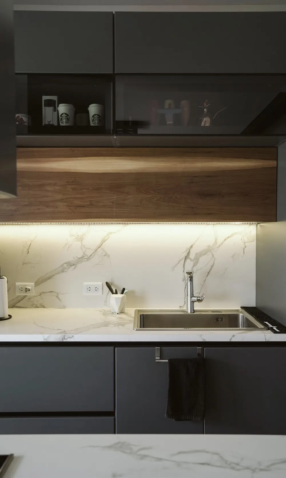 Cocina en grafito y roble con encimera efecto mármol y luz bajo mueble