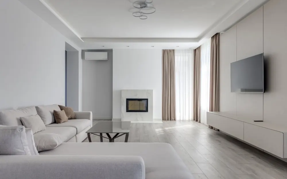 Salón reformado con falso techo, luz perimetral, chimenea integrada y mueble de televisión lacado a medida